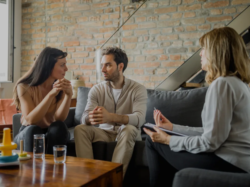 Couple sitting together in therapy, looking thoughtful rather than distressed.