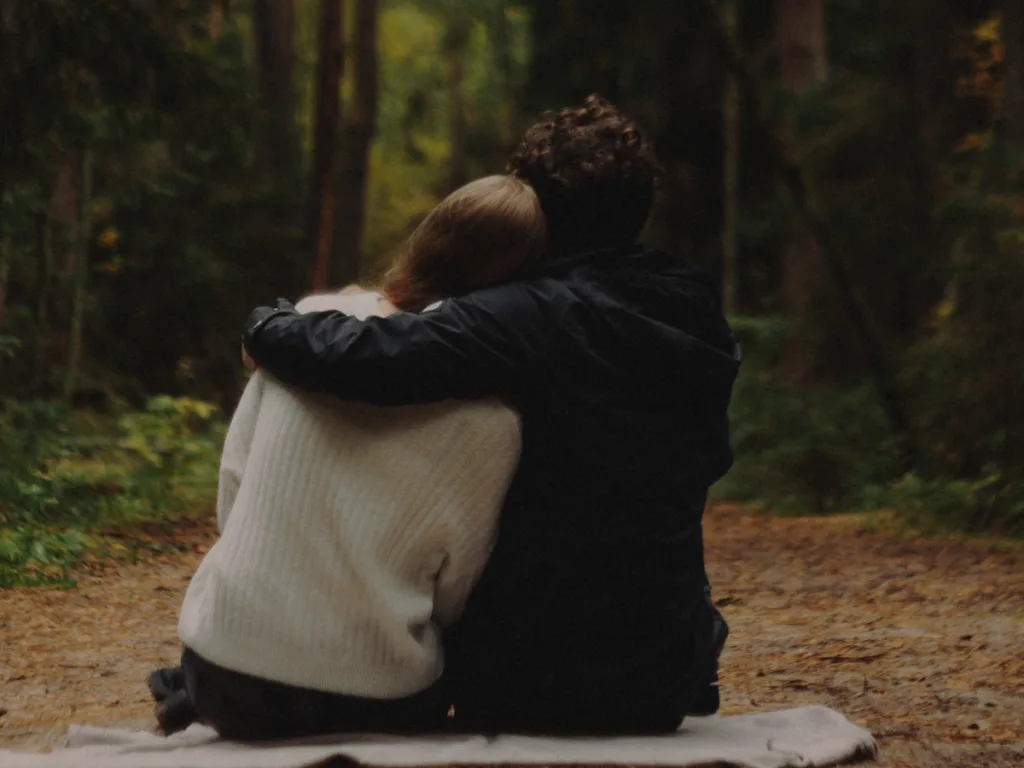 Two couples sitting comfortably together in a forest.